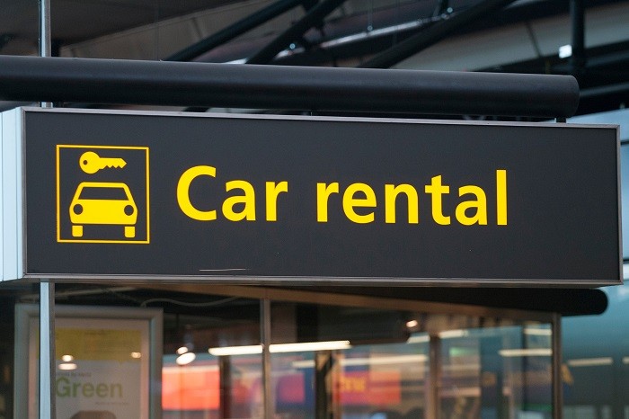 黒地の看板に、黄色の車のアイコンと、Car rentalの文字が書かれている