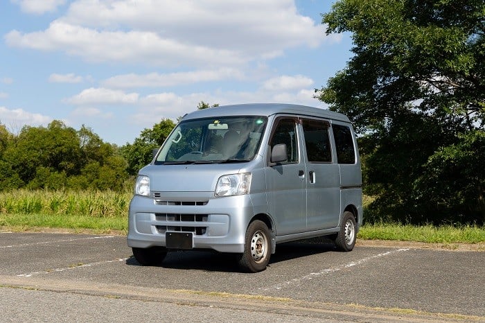 シルバーの貨物軽自動車が駐車場に停まっている