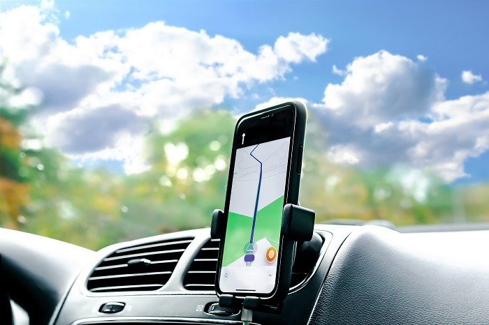 自動車の車内の運転席前方に、地図アプリを表示したスマートフォンが設置されている