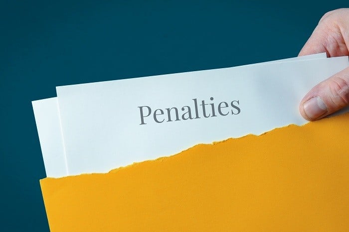 「Penalties(罰則)」と書かれた書類が、黄色の封筒から取り出される様子